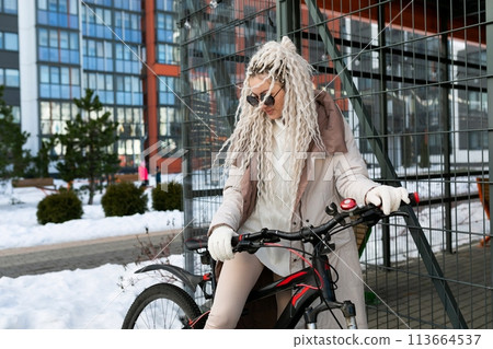 Woman With Long White Hair Riding Bike in Snow Woman With Long White Hair Riding Bike in Snow 113664537