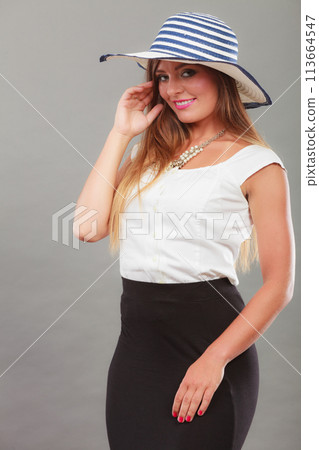 Woman wearing long black white dress and sun hat Woman wearing long black white dress and sun hat 113664547