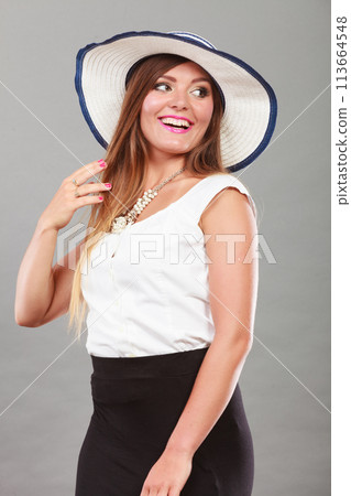 Woman wearing long black white dress and sun hat Woman wearing long black white dress and sun hat 113664548