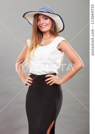 Woman wearing long black white dress and sun hat 113664550
