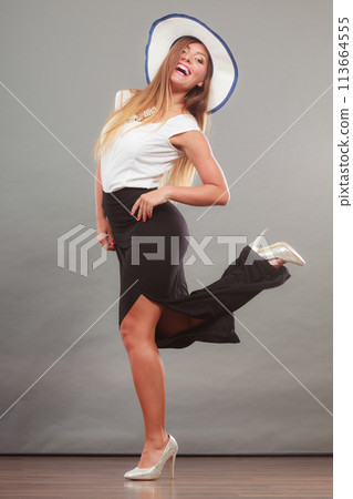 Woman wearing long black white dress and sun hat Woman wearing long black white dress and sun hat 113664555