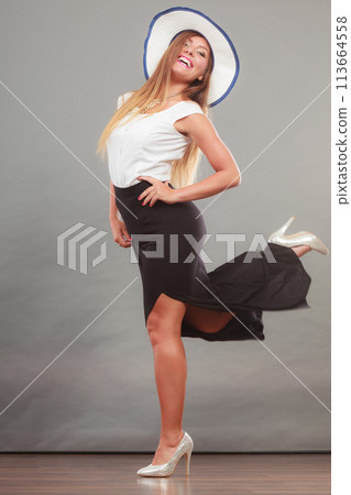 Woman wearing long black white dress and sun hat Woman wearing long black white dress and sun hat 113664558