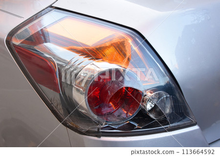 Close up of headlight of a car with red light on. Close up of headlight of a car with red light on. 113664592