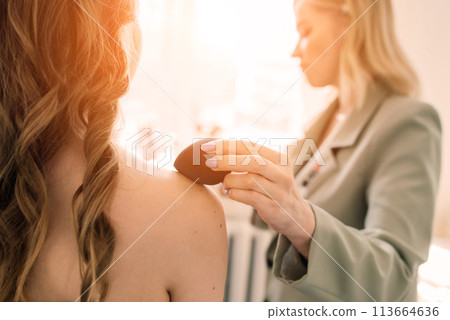 Woman make-up artist work in her studio with model 113664636