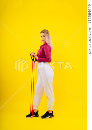 Athletic female performs exercises using a resistance band. Strength and motivation Athletic female performs exercises using a resistance band. Strength and motivation 113664649