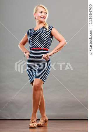 Mid adult woman in summer striped dress Mid adult woman in summer striped dress 113664700