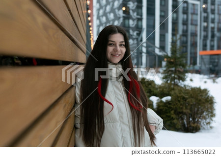 Woman Standing Next to Wooden Wall in Snow Woman Standing Next to Wooden Wall in Snow 113665022