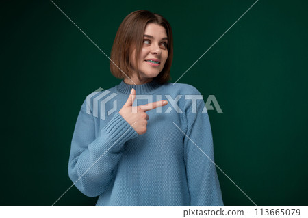 Woman in Blue Sweater Points at Something 113665079