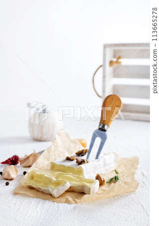 camambert cheese with nuts on white table camambert cheese with nuts on white table 113665278