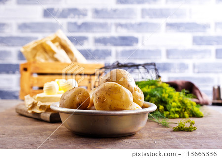 Fresh raw baby potato in bowl on wooden background. Fresh raw baby potato in bowl on wooden background. 113665336