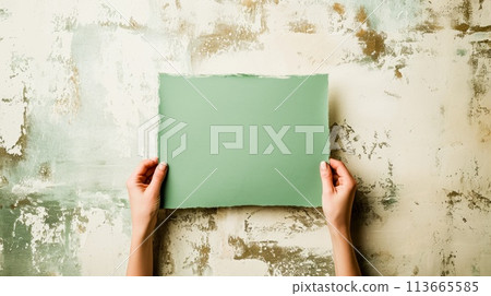 A person holding a piece of paper against an old wall, AI 113665585