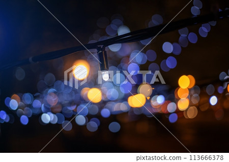 Street garland near view, decoration of the city for the New Year and Christmas holidays. Beautiful blurred lights-bokeh in the background. 113666378