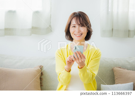 操作智慧型手機的中年婦女 操作智慧型手機的中年婦女 113666397
