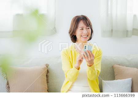 操作智慧型手機的中年婦女 操作智慧型手機的中年婦女 113666399