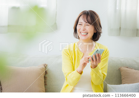 A middle-aged woman operating a smartphone A middle-aged woman operating a smartphone 113666400