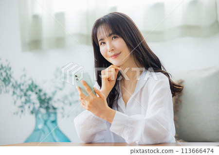 A woman watching a smartphone A woman watching a smartphone 113666474