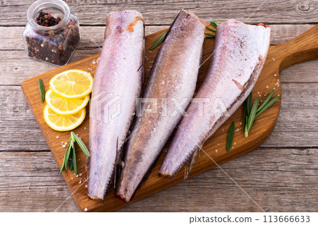 Raw hake on wooden background 113666633