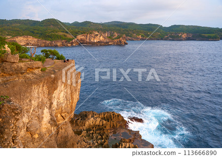 Cinematic aerial landscape shots of the beautiful island of Nusa Penida. Huge cliffs by the shoreline and hidden dream beaches with clear water and foaming wave. Cinematic aerial landscape shots of the beautiful island of Nusa Penida. Huge cliffs by the shoreline and hidden dream beaches with clear water and foaming wave. 113666890