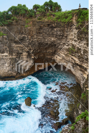 Cinematic aerial landscape shots of the beautiful island of Nusa Penida. Huge cliffs by the shoreline and hidden dream beaches with clear water and foaming wave. Cinematic aerial landscape shots of the beautiful island of Nusa Penida. Huge cliffs by the shoreline and hidden dream beaches with clear water and foaming wave. 113666904