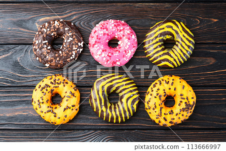 Set of colorful donuts on wooden background 113666997