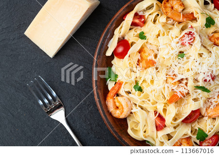 Italian pasta with shrimps , parmesan and tomatoes 113667016