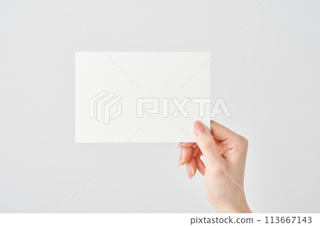 Woman's hand holding a white piece of paper 113667143