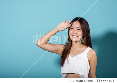 Asian young woman hand up cover face protect sun light and UV smile in studio shot isolated on blue background, female raising arm and hand in protection and block sunshine, sunscreen cream advertise Asian young woman hand up cover face protect sun light and UV smile in studio shot isolated on blue background, female raising arm and hand in protection and block sunshine, sunscreen cream advertise 113667491