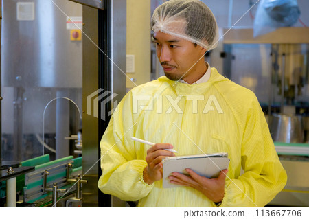 Technician young man checking and maintenance quality of producing automated machine bottling wine. 113667706