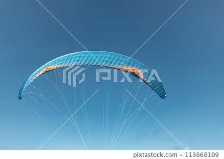 Colorful paraglider close-up against the blue sky Colorful paraglider close-up against the blue sky 113668109