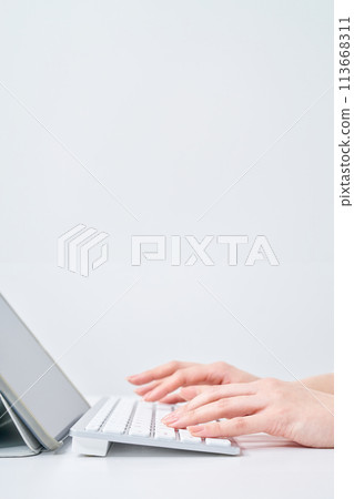 A woman's hands typing on a keyboard A woman's hands typing on a keyboard 113668311