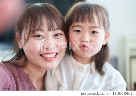 Parents and children taking selfies with a smartphone: Girl and mother Parents and children taking selfies with a smartphone: Girl and mother 113668461