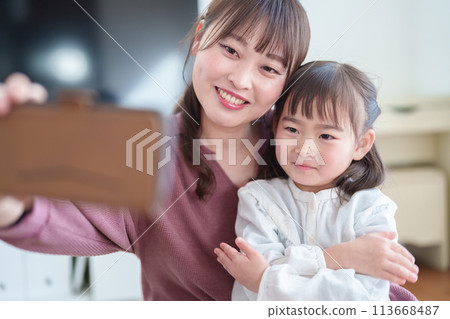Parents and children taking selfies with a smartphone: Girl and mother 113668487