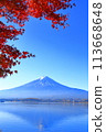 A view of Mt. Fuji shining against the blue sky with the autumn leaves of Lake Kawaguchi in the foreground 113668648