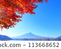 A view of Mt. Fuji shining against the blue sky with the autumn leaves of Lake Kawaguchi in the foreground 113668652