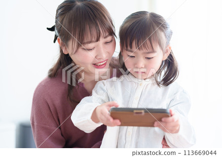 Parents and children using smartphones: girl and mother Parents and children using smartphones: girl and mother 113669044