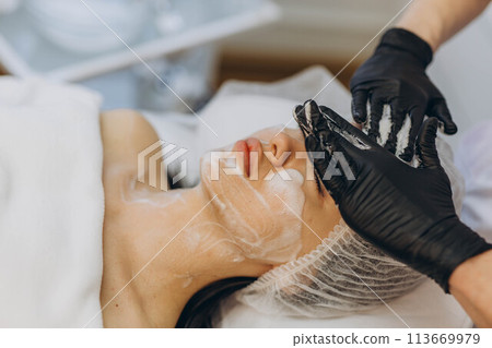 woman at the cosmetologist. She has problem skin and acne. 113669979