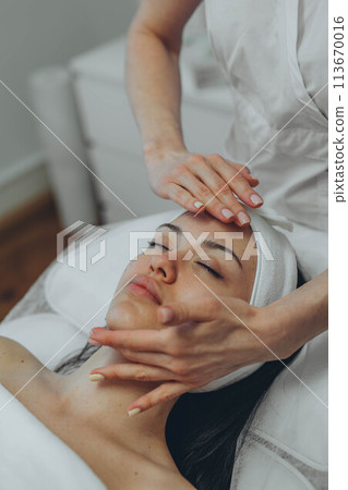girl at a cosmetologist's office doing skin cleansing girl at a cosmetologist's office doing skin cleansing 113670016