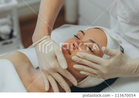 girl at a cosmetologist's office doing skin cleansing 113670054