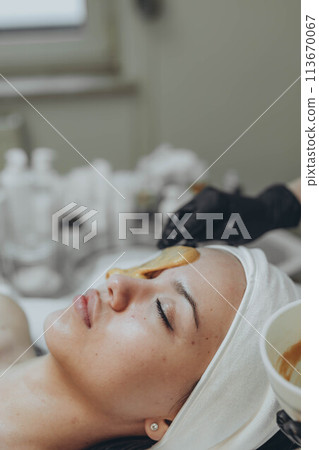 A girl at a cosmetologist does cosmetic procedures. Alginate mask 113670067