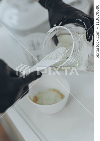 A woman cosmetologist makes an alginate mask 113670080