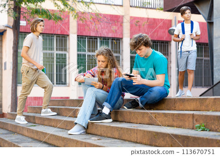 Boy and girl teens sitting on stairs and doing homework 113670751