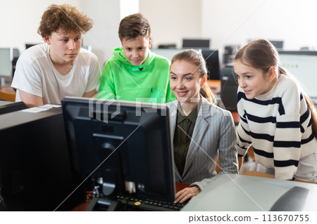 Teacher helping girl and boys to solve computer problem Teacher helping girl and boys to solve computer problem 113670755