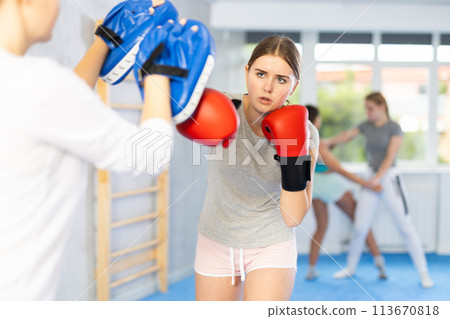 Teen girl in punch mitts boxing Teen girl in punch mitts boxing 113670818