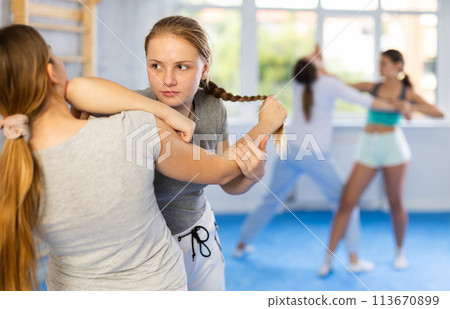 Two teenage girls training in group self defense classes 113670899