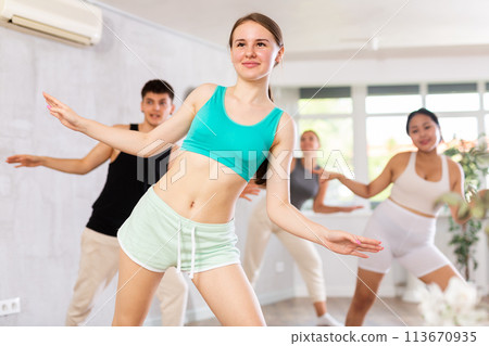 Girl teen perform choreographic exercise and teach energetic mobile social dance groove with friends Girl teen perform choreographic exercise and teach energetic mobile social dance groove with friends 113670935