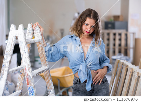 Tempting woman in revealing attire posing in construction site 113670970