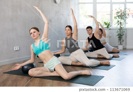 Group of young people doing softball pilates. Group of young people doing softball pilates. 113671069