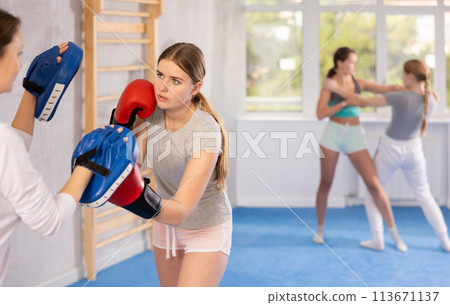 Teen girl in punch mitts boxing 113671137