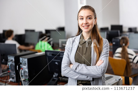 Portrait of positive woman teacher standing in computer class 113671237