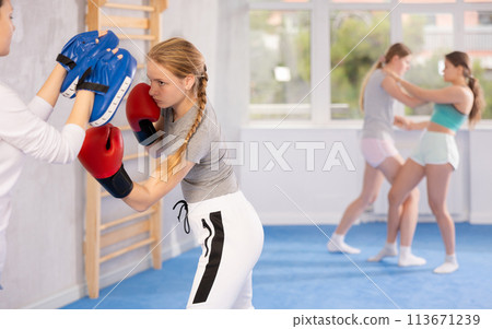 Teen girl in punch mitts boxing 113671239